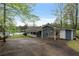Home's exterior with carport, showing a well-manicured yard and a view of the lake in the background at 7650 Rico Rd, Chattahoochee Hills, GA 30268