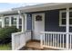 Welcoming front entrance with a white door, a wreath, and a small porch, offering a charming arrival at 7650 Rico Rd, Chattahoochee Hills, GA 30268