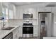 Bright kitchen features stainless steel appliances, granite countertops, and white cabinets at 7650 Rico Rd, Chattahoochee Hills, GA 30268