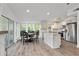 Bright kitchen with an island, stainless steel appliances, and a view of the outdoor dining area at 7650 Rico Rd, Chattahoochee Hills, GA 30268