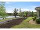 Beautiful lawn with landscaped beds and a glimpse of the tranquil lake at 7650 Rico Rd, Chattahoochee Hills, GA 30268