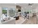 Bright and open living room featuring a stone fireplace, hardwood floors, and lake views at 7650 Rico Rd, Chattahoochee Hills, GA 30268