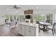 Open-concept living and eat-in kitchen area with stone fireplace and screened in patio access at 7650 Rico Rd, Chattahoochee Hills, GA 30268