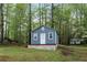 Charming blue outbuilding with white trim nestled among the trees at 7650 Rico Rd, Chattahoochee Hills, GA 30268