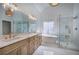A luxurious bathroom with double vanity, soaking tub under stained-glass window, and glass enclosed shower at 1043 Middlebrooke Dr, Canton, GA 30115