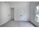 Cozy bedroom with soft gray carpet, double closet doors, and a window that offers a pleasant view at 1043 Middlebrooke Dr, Canton, GA 30115
