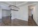 Open concept dining room with wainscoting, modern chandelier, and view to staircase at 1043 Middlebrooke Dr, Canton, GA 30115