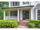 Inviting front porch with white columns, black shutters, and colorful, manicured landscaping at 1043 Middlebrooke Dr, Canton, GA 30115