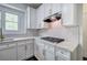 Bright kitchen showcasing white cabinets, marble countertops, and a herringbone backsplash at 1043 Middlebrooke Dr, Canton, GA 30115