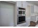 Gourmet kitchen showcasing stainless steel microwave and oven appliances with stylish white cabinets and gold hardware at 1043 Middlebrooke Dr, Canton, GA 30115