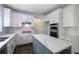 Bright kitchen boasts white cabinets, quartz countertops, stainless appliances, and center island at 1043 Middlebrooke Dr, Canton, GA 30115