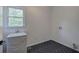 Well-lit laundry room with a utility sink and herringbone-patterned floor tiles at 1043 Middlebrooke Dr, Canton, GA 30115