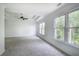 Bright main bedroom with neutral carpet, ceiling fan, and three large windows at 1043 Middlebrooke Dr, Canton, GA 30115