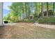 Expansive backyard featuring mature trees, a stone retaining wall, and access to a deck at 1916 Oakwood Grove Dr, Snellville, GA 30078