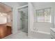 Bright bathroom featuring a glass shower with marble tile and a soaking tub under a window at 1916 Oakwood Grove Dr, Snellville, GA 30078