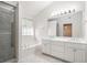 Bright bathroom featuring double vanity, soaking tub, large mirror, and glass-enclosed shower at 1916 Oakwood Grove Dr, Snellville, GA 30078