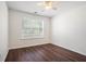 Bedroom features wood flooring, a ceiling fan, and a large window at 1916 Oakwood Grove Dr, Snellville, GA 30078