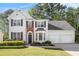 Charming two-story home with a well-manicured lawn and elegant architectural details like a brick arch at 1916 Oakwood Grove Dr, Snellville, GA 30078