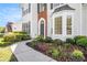 Beautifully landscaped front yard with a curved walkway leading to an elegant home entrance at 1916 Oakwood Grove Dr, Snellville, GA 30078