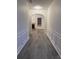 Hallway with grey wood floors and arched doorways with white trim and paint at 1916 Oakwood Grove Dr, Snellville, GA 30078