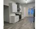 Modern kitchen with stainless steel appliances, white cabinets, gray floors, and marble countertops at 1916 Oakwood Grove Dr, Snellville, GA 30078
