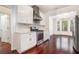 Bright kitchen with stainless steel appliances, white cabinets, and hardwood floors that transition to a dining area at 1916 Oakwood Grove Dr, Snellville, GA 30078