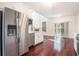 Open-concept kitchen with stainless steel refrigerator, island, and flows into bright living area and view of fireplace at 1916 Oakwood Grove Dr, Snellville, GA 30078