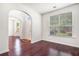 Bright living room features hardwood floors, arched doorway, and large window showcasing the exterior at 1916 Oakwood Grove Dr, Snellville, GA 30078