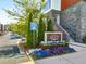 Townhome community with a beautifully landscaped entrance sign and colorful flowers along the street at 383 Pratt Se Dr # 504, Atlanta, GA 30315