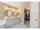 Luxurious bathroom with double vanity, modern lighting and a glass shower with tub in background at 4223 Millside Se Walk, Smyrna, GA 30080