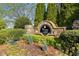 Stone entrance sign for Vinings Mill West surrounded by lush greenery and colorful flowering plants at 4223 Millside Se Walk, Smyrna, GA 30080
