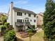 Rear exterior displaying a two-story home with a deck, patio, and lush landscaping in a serene backyard setting at 4223 Millside Se Walk, Smyrna, GA 30080