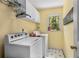 Functional laundry room with white cabinetry, side-by-side washer and dryer, and natural light at 4223 Millside Se Walk, Smyrna, GA 30080