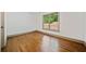This bedroom features hardwood floors, a window with a view, and white walls at 5017 Spring Hill Dr, Sugar Hill, GA 30518