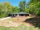 Scenic view of a home with a carport surrounded by lush greenery and mature trees at 5017 Spring Hill Dr, Sugar Hill, GA 30518