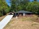Well-maintained home with a long, modern driveway, carport, and lush green surroundings at 5017 Spring Hill Dr, Sugar Hill, GA 30518
