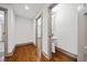 Hallway with wood floors leads to a half bathroom with pedestal sink and gray trim at 5017 Spring Hill Dr, Sugar Hill, GA 30518