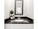Elegant bathroom vanity featuring a black granite countertop and modern mirror at 7154 Sw Chara Sw Ln, Atlanta, GA 30331