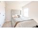 Bright bedroom featuring a large, tufted headboard and natural light from the window at 7154 Sw Chara Sw Ln, Atlanta, GA 30331