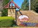 Stone community sign with colorful flowers and landscaping at the entrance of Anatole at 7154 Sw Chara Sw Ln, Atlanta, GA 30331