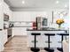 Bright kitchen featuring white cabinets, black countertops, stainless steel appliances, and bar seating at 7154 Sw Chara Sw Ln, Atlanta, GA 30331