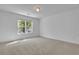 Bright bedroom featuring neutral carpet, a large window letting in natural light, and fresh white walls at 1353 Midlawn Dr, Decatur, GA 30032
