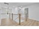 Hallway view showing a hardwood floor, white railing, and a modern light fixture above at 1353 Midlawn Dr, Decatur, GA 30032