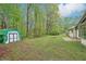 The backyard offers a shed, level lawn and shade trees, providing ample space for outdoor activities and storage at 3719 Bomar Rd, Douglasville, GA 30135