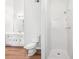 Well-lit bathroom with white fixtures, including a toilet, shower, and vanity at 3719 Bomar Rd, Douglasville, GA 30135
