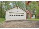 Two-car attached garage with brick accents and an arched window at 3719 Bomar Rd, Douglasville, GA 30135
