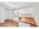 Spacious eat-in kitchen with wood countertops, white cabinets, hardwood flooring, and stainless steel sink at 3719 Bomar Rd, Douglasville, GA 30135
