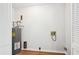 Unfinished laundry room with exposed plumbing, a hot water tank, and white louvered doors at 3719 Bomar Rd, Douglasville, GA 30135