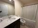 Bright bathroom features a vanity with sink, toilet, bathtub with shower curtain, and a mirror at 4215 Almanor Cir, Norcross, GA 30071