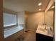 Bright bathroom featuring a large window, soaking tub, double vanity, and neutral tile flooring at 4215 Almanor Cir, Norcross, GA 30071